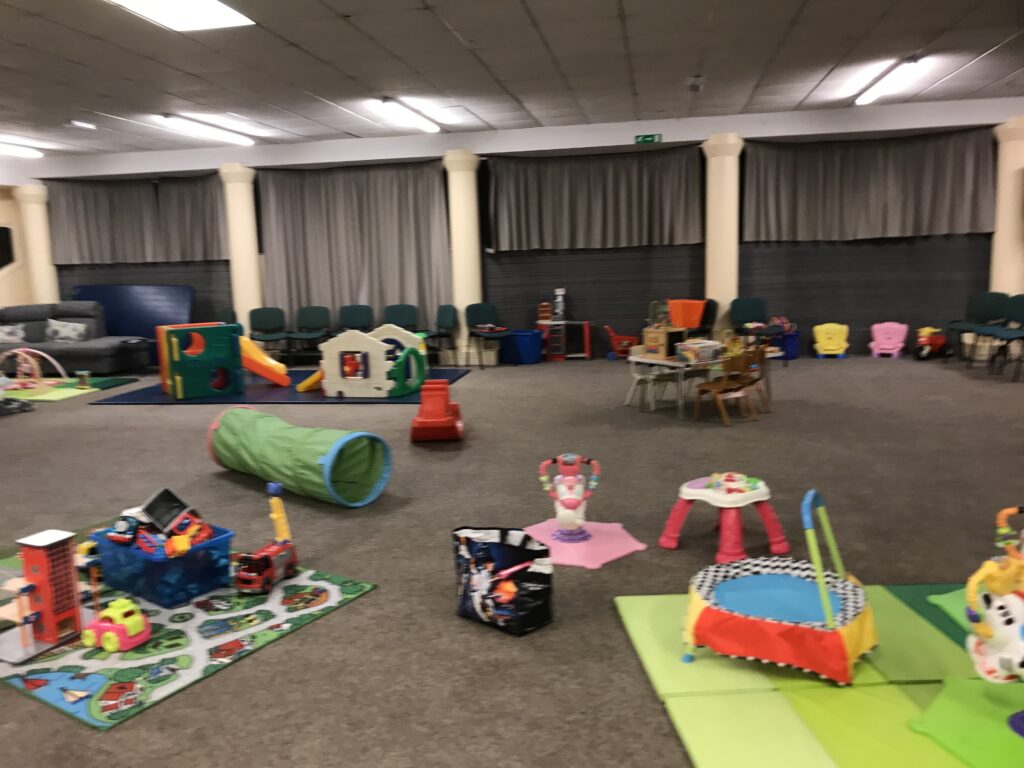 picture shows a hall with childrens toys scattered around